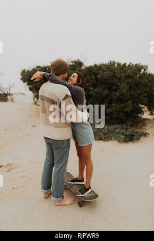 Giovane romantico lo skateboard giovane faccia a faccia sulla spiaggia, Jalama, CALIFORNIA, STATI UNITI D'AMERICA Foto Stock