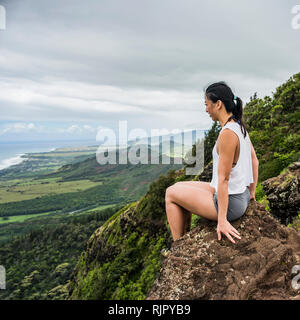 Escursionista su roccia sulla cima della montagna, Sleeping Giant Trail, Kauai, Hawaii Foto Stock
