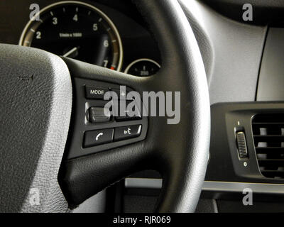I pulsanti di comando e interfaccia di comando vocale sul volante all'interno di un automobile Foto Stock