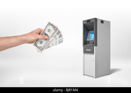 Man mano del dollaro di contenimento di banconote e di raggiungere per un ATM su uno sfondo bianco. La pianificazione di bilancio. Caricamento di account. Il deposito di contanti. Foto Stock