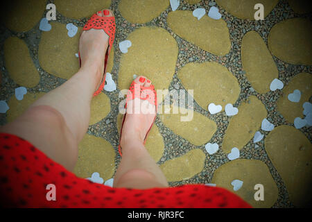 I piedi delle donne ad un matrimonio con scarpe e abiti arancioni Foto Stock