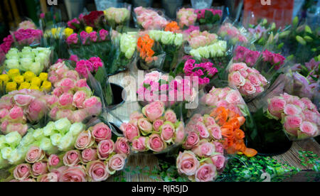 Vista panoramica di mazzi di rose in un'ampia gamma di colori, rosa, rossa, bianca e gialla, allo stand di un mercato floreale Foto Stock