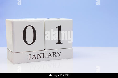 Gennaio 01st. Giorno 01 del mese, il calendario giornaliero sul tavolo bianco con la riflessione, con luce sfondo blu. Orario invernale, spazio vuoto per il testo Foto Stock