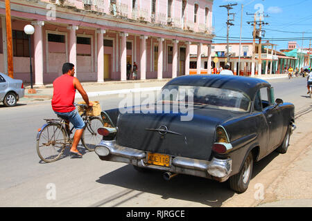 MORON, CUBA - 19 febbraio: ciclista passa di vecchia auto il 19 febbraio 2011 di Moron, Cuba. Recente modifica della legge consente i cubani al commercio di automobili di nuovo. Foto Stock