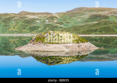 La riflessione di isola nel Lago di Tyin circondato da montagne Jutunheimen, vicino, Norvegia, Europa Foto Stock