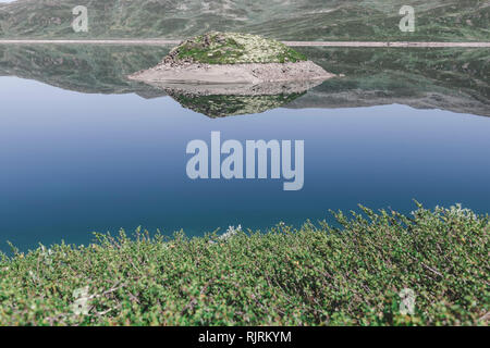 Isola nel lago di Tyin circondato da montagne Jutunheimen, Norvegia, Europa Foto Stock
