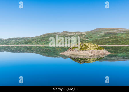 Isola nel lago di Tyin circondato da montagne Jutunheimen, Norvegia, Europa Foto Stock