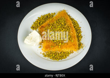 Tradizionale dessert turco Kunefe isolati su nero. Foto Stock