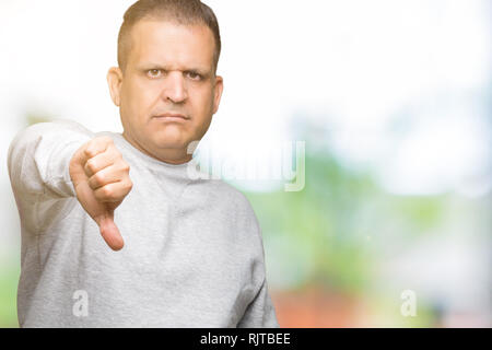 La mezza età uomo arabo indossando felpa sportiva su sfondo isolato cercando infelice e arrabbiato che mostra il rifiuto e negativo con il pollice verso il basso gestur Foto Stock