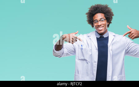 Afro American medico scienziato uomo sullo sfondo isolato guardando fiduciosi con il sorriso sul volto, rivolto a se stessi con le dita orgogliosa e felice. Foto Stock