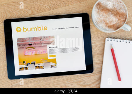 Il Bumble dating app funzionalità del sito su un iPad dispositivo tablet pc che si appoggia su una tavola di legno accanto a un blocco note (solo uso editoriale). Foto Stock