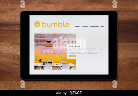 Il sito di dating Bumble app è visto su un tablet iPad, il quale è appoggiato su un tavolo di legno (solo uso editoriale). Foto Stock