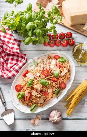La pasta italiana spaghetti alla bolognese in bianco ciotola con pomodori formaggio parmigiano e basilico Foto Stock
