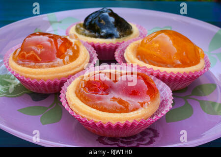 Punnets di pasta riempita con vari frutti canditi, servita in rosa lastra di vetro, vicino, vista laterale Foto Stock