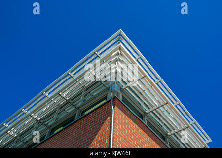 Angolo di un edificio con tetto di griglia di affiancamento al di sopra delle finestre. Foto Stock