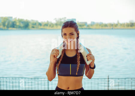 Allegra donna atletica sul terrapieno di città Foto Stock