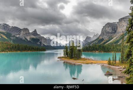 Isola in un lago, spirito isola nel lago glaciale Lago Maligne, dietro le montagne Monte Paolo, Monkhead e Monte Warren, Foto Stock