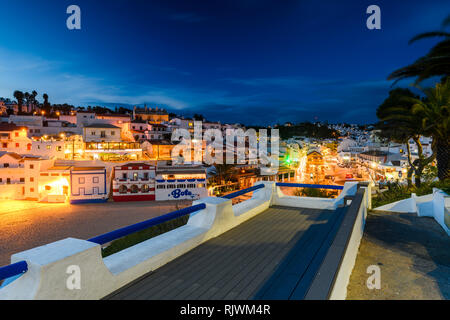 Case illuminate e sulla spiaggia al tramonto, Carvoeiro, Algarve, Portogallo, Europa Foto Stock