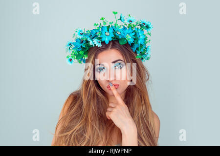Giovane e bella donna che indossa anemone archetto floreali crown isolati su fondo azzurro. con archetto da fiori sulla testa guardando a voi camer Foto Stock