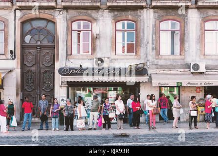 La gente in attesa su una fermata di autobus di Lisbona. Foto Stock