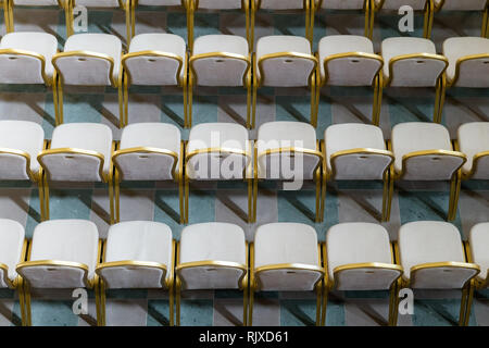 File di disco tradizionali sedie di legno con morbido cuscino e bordatura dorata per incontri formali, conferenze, lezioni, cerimonie di laurea Foto Stock