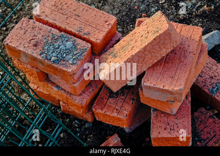 Mattoni rossi sparsi su un cantiere di close-up Foto Stock