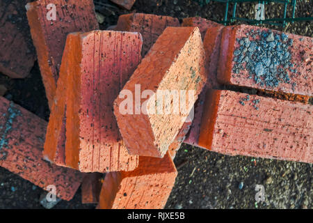 Mattoni rossi sparsi su un cantiere di close-up Foto Stock