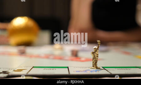 Vista ingrandita della miniatura statua liberty carattere sul gioco desktop mentre la famiglia gioca in casa Foto Stock