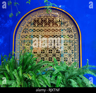 Tipico, vecchio, ornati intricate sculture, costellata, riad marocchino finestrino e il telaio e la vecchia casa. Bellissima vista della parete blu nella medina. Foto Stock