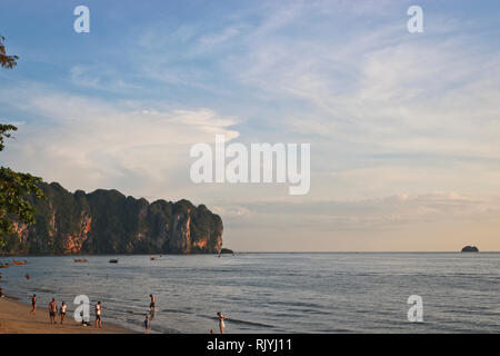 Bellissima costa tropicale della Thailandia che si affaccia sulla spiaggia, mare azzurro, palme e turisti, Krabi Ao Nang. In bella luce del tramonto Foto Stock