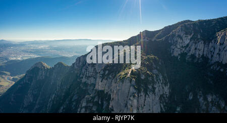 Antenna; drone vista di multi-picco gamma di montagna vicino a Barcellona; inverno pieno di sole giorno limpido e azzurro skyline; eruzione del vulcano ha portato alla emer Foto Stock