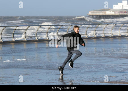 Blackpool, Lancashire. 8 febbraio, 2019. Regno Unito Meteo. Venti forti sul lungomare a marea alta. Molto ventoso condizioni come persone schivare le onde sul promontorio della torre il rischio di ottenere completamente imbevuto nel gale force condizioni. Credito: MediaWorldImages/AlamyLiveNews. Foto Stock