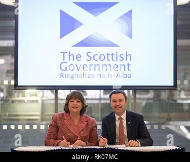 Glasgow, Regno Unito. 8 Feb 2019. (Sinistra) Fiona Hyslop MSP - Armadio Segretario per la cultura, turismo e affari esterni, e (a destra) David Lappartient - Presidente della Union Cycliste Internationale della firma di un accordo. Un nuovo multi-disciplinare, ciclismo manifestazione riunirà 13 UCI esistenti del campionato del mondo di ciclismo in un evento che si terrà ogni quattro anni e per la prima volta a Glasgow e in Scozia nel 2023. Credito: Colin Fisher/Alamy Live News Foto Stock