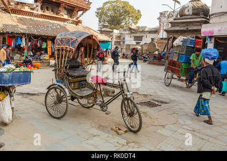 Kathmandu, Nepal - Novembre 25, 2016: un rickshaw sorge sulla strada di Kathmandu. In Nepal i trasporti quali pedicabs è ancora comune. Foto Stock