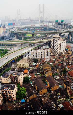 Baraccopoli alloggiamento con Ponte di Nanpu in background Foto Stock