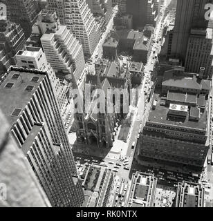 Degli anni Cinquanta, storico, veduta aerea i grattacieli e gli edifici di Manhattan a New York, USA, con la chiesa cattolica romana sulla Cattedrale di San Patrizio e Fifth Avenue, mostrando i tetti con segni di noti negozi americano di Saks Fifth Avenue e migliore & Co. Foto Stock