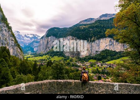 La valle di Lauterbrunnen, vicino a Interlaken nell Oberland Bernese, Svizzera. Hipster ragazza si siede e godetevi la vista. Foto Stock