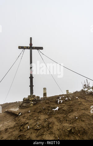 Croce smerigliato su un picco di montagna delle Alpi con la neve Foto Stock