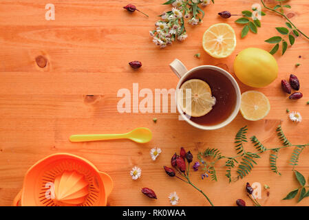 Rosa canina tisana laici flat top view con fettina di limone sul tavolo di legno Foto Stock