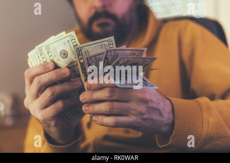 Uomo informale è il conteggio dollaro americano banconote, close up delle mani con il denaro Foto Stock