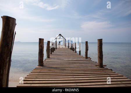 Il vecchio uomo si siede sul molo e guarda al mare Foto Stock