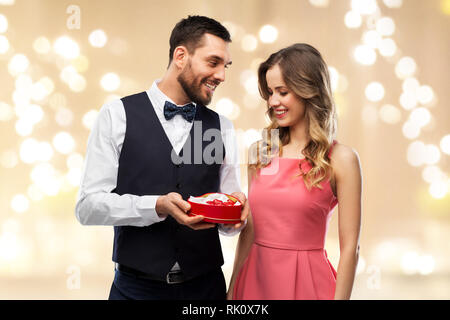 Coppia felice con scatola di cioccolatini a forma di cuore Foto Stock