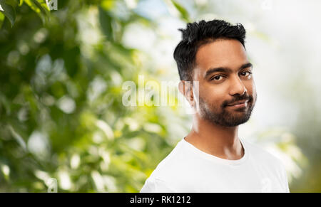 Sorridente giovane uomo indiano su sfondo grigio Foto Stock