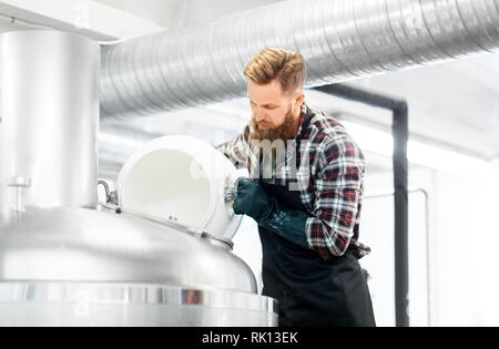 Uomo che lavora alla birreria artigianale o impianto di birra Foto Stock