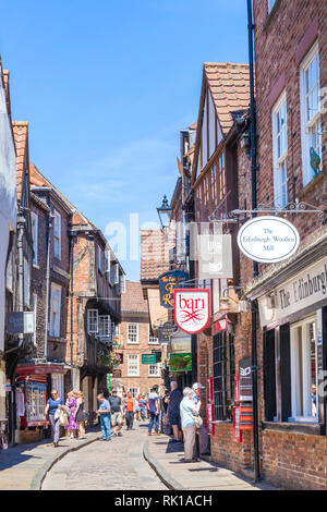 I turisti a piedi verso il basso il caos della strada stretta del mezzo in legno vecchio edifici medievali York Yorkshire England Regno Unito GB Europa Foto Stock