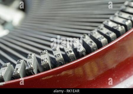 Un primo piano della lettera di blocchi sui bracci di riscontro di un antico nastri inchiostratori per macchine da scrivere con la focalizzazione sulla lettera X. Foto Stock