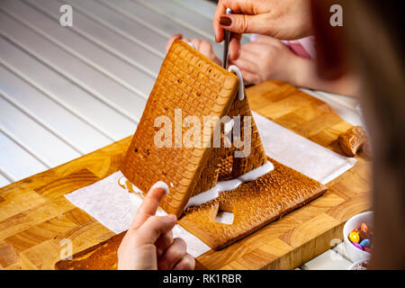Familiy costruire un dolce pane di zenzero house. Foto Stock