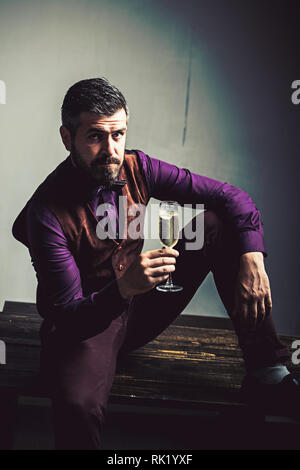 Uomo Barbuto bere vino. Coppia hipster con la barba. brutale caucasian hipster con baffi. Fiducioso uomo brutale. Imprenditore. sommelier. Provare questo Foto Stock