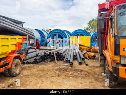 Operai in un cantiere e tubi di scarico da un camion in Jimbaran, Bali Indonesia. Foto Stock