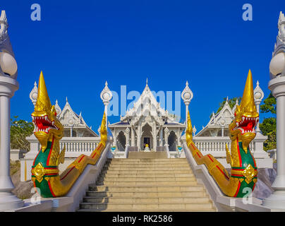 Ornato e colorato golden naga statue davanti alla White Thai tempio buddista di Wat Kaew Korawaram a Krabi, Thailandia Foto Stock